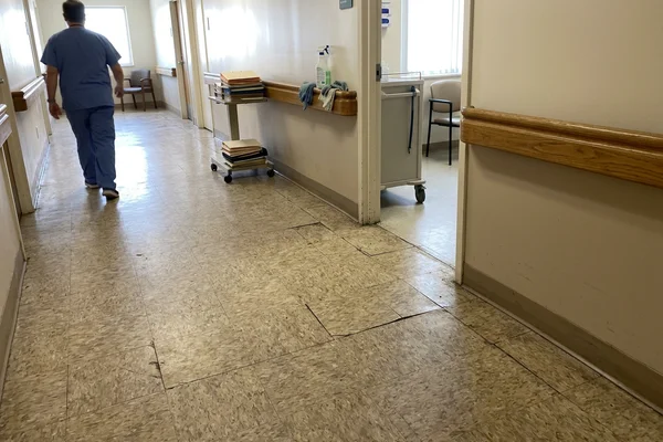 Aging VCT clinic corridor before sheet vinyl replacement