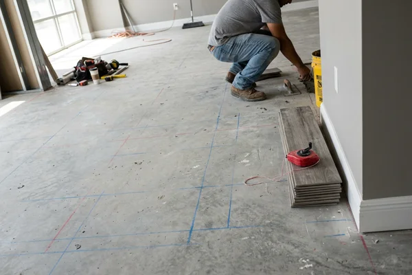 Prepared and primed commercial slab with layout lines ready for installation