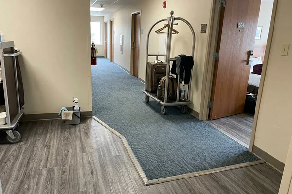 Hospitality floor in commercial LVT meeting carpet tile at a transition strip