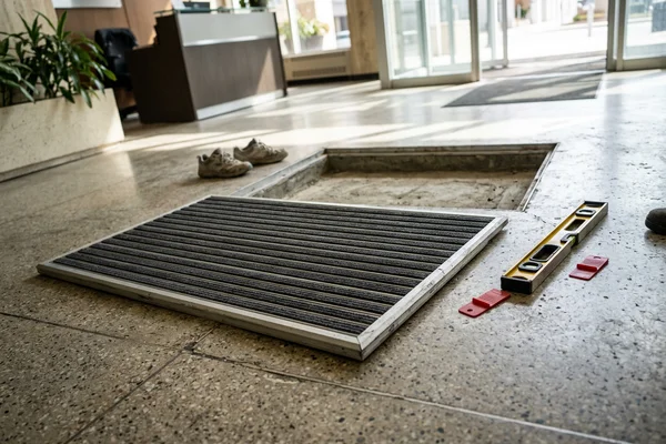 Aluminum entrance grille with carpet tread inserts before being set into its frame