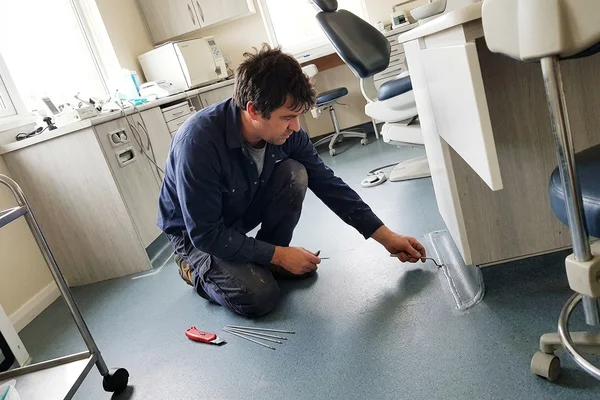 Technician checking a finished thermal weld bead in a dental surgery
